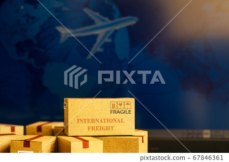 Small paper boxes on notebook with a plane flies behind. An ideas about transportation, international freight, global shipping, overseas trade, regional, or local forwarding. Small paper boxes on notebook with a plane flies behind. An ideas about transportation, international freight, global shipping, overseas trade, regional, or local forwarding. 67846361