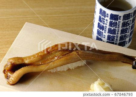 A handful of conger eel and tea on sushi geta 67846793