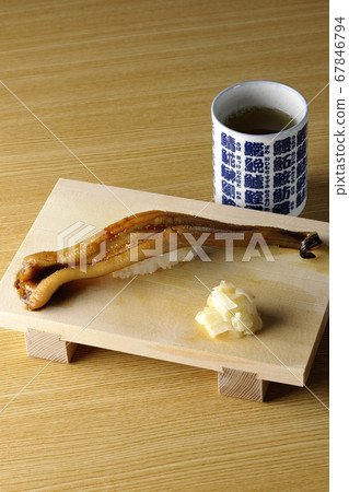 A handful of conger eel and tea on sushi geta 67846794