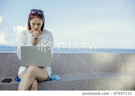 Asian female praying to god in front of a laptop Asian female praying to god in front of a laptop 67847113