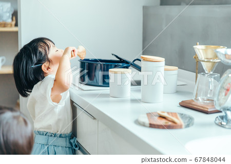 白色廚房裡的一個女孩正在從鍋裡吃著零食廚房裡的女孩吃 白色廚房裡的一個女孩正在從鍋裡吃著零食廚房裡的女孩吃 67848044