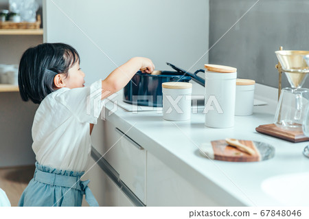 一個女孩在一個白色的廚房裡攪拌女孩鍋 一個女孩在一個白色的廚房裡攪拌女孩鍋 67848046