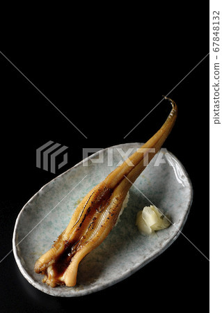A handful of roasted conger eel served on a plate (black background) A handful of roasted conger eel served on a plate (black background) 67848132