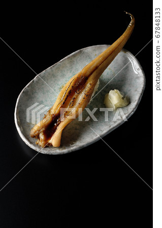 A handful of roasted conger eel served on a plate (black background) A handful of roasted conger eel served on a plate (black background) 67848133
