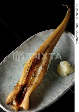 A handful of roasted conger eel served on a plate (black background) A handful of roasted conger eel served on a plate (black background) 67848135