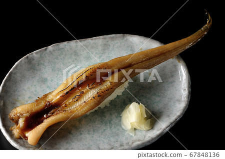A handful of roasted conger eel served on a plate (black background) A handful of roasted conger eel served on a plate (black background) 67848136
