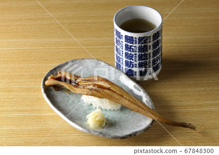 盤子上放有少量烤鰻魚和茶 盤子上放有少量烤鰻魚和茶 67848300