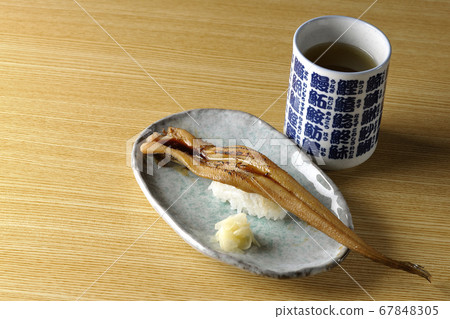 盤子上放有少量烤鰻魚和茶 67848305