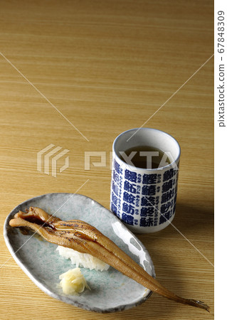 A handful of grilled conger eel and tea served on a plate 67848309