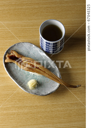 盤子上放有少量烤鰻魚和茶 67848325