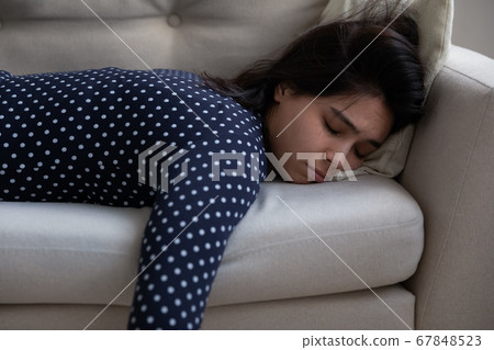 Exhausted Asian girl fall asleep on couch at home Exhausted Asian girl fall asleep on couch at home 67848523