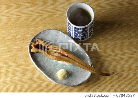 A handful of roasted conger eel served on a plate and hot tea A handful of roasted conger eel served on a plate and hot tea 67848557