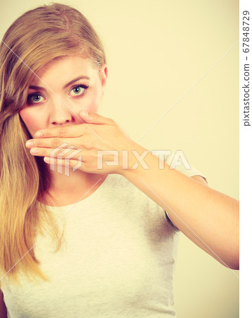 Ashamed woman having hand on mouth 67848729