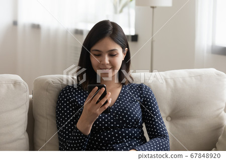 Millennial Vietnamese girl using cellphone relaxing at home Millennial Vietnamese girl using cellphone relaxing at home 67848920