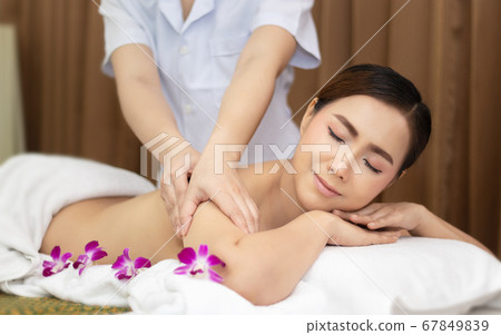 beautiful young Asian woman relaxing with hand massage on naked back body by masseur at beauty spa treatment. relaxing massage beautiful young Asian woman relaxing with hand massage on naked back body by masseur at beauty spa treatment. relaxing massage 67849839