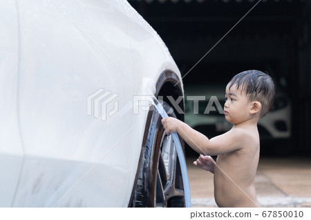 Asian child baby boy washing car in the garden on 67850010