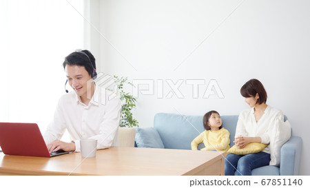 Father teleworking in the living room Father teleworking in the living room 67851140