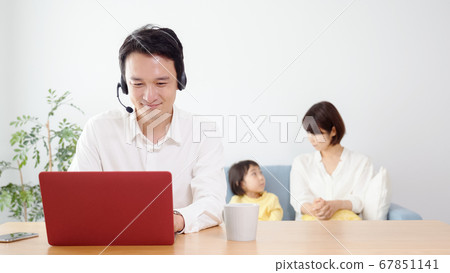 Father teleworking in the living room Father teleworking in the living room 67851141
