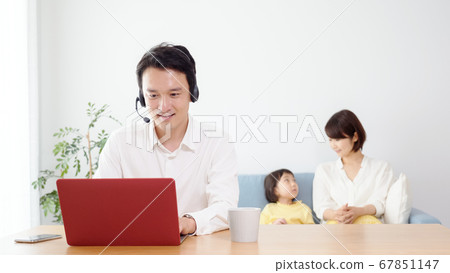 Father teleworking in the living room Father teleworking in the living room 67851147