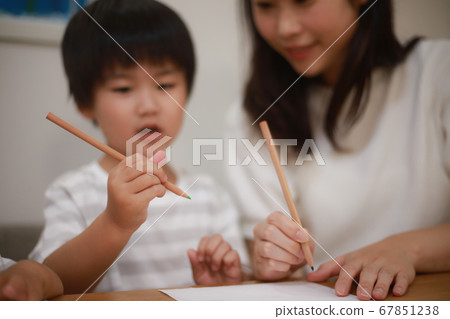 Parents and children practicing how to hold pencils 67851238