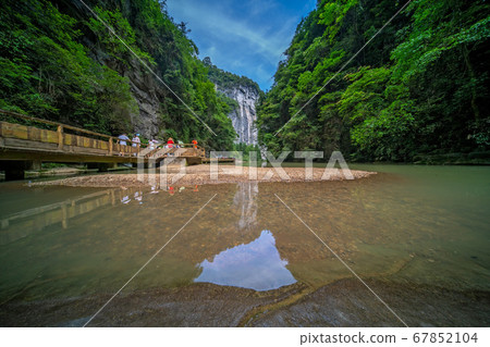 Tourists on a path along river in Wulong National 67852104
