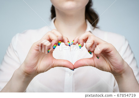 Photo of woman with rainbow manicure showing heart 67854719