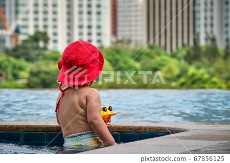 Manila, Philippines - Feb 02, 2020. Little girl in the pool on the roof of the hotel. View of the city of Manila from the pool of the luxury five-star Discovery Primea hotel. Sunny weather Manila, Philippines - Feb 02, 2020. Little girl in the pool on the roof of the hotel. View of the city of Manila from the pool of the luxury five-star Discovery Primea hotel. Sunny weather 67856125