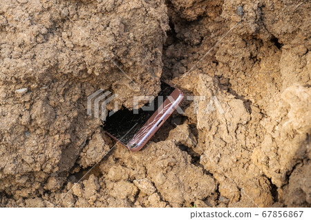 broken phone in the ground 67856867