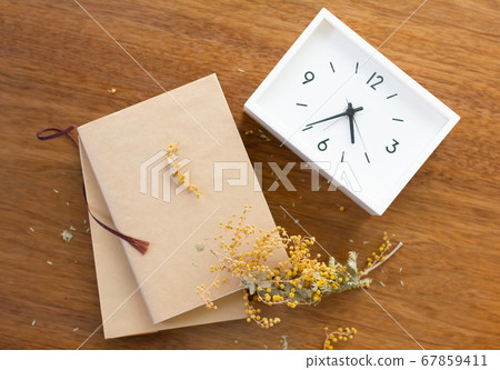 Mimosa dried flower, book and table clock Mimosa dried flower, book and table clock 67859411