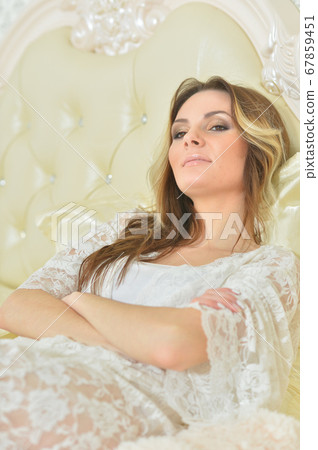 Portrait of young beautiful woman posing in bed Portrait of young beautiful woman posing in bed 67859451