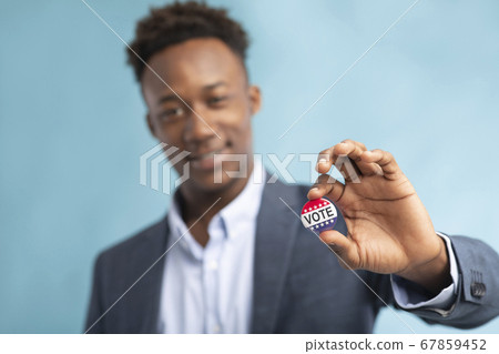 African american man showing his Vote button, he voted African american man showing his Vote button, he voted 67859452