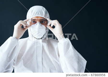 Doctor in PPE wearing protective glasses on black background Doctor in PPE wearing protective glasses on black background 67860956