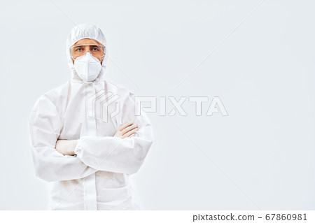 Confident doctor with crossed arms in protective medical suit Confident doctor with crossed arms in protective medical suit 67860981