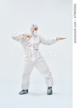 Full lenght portrait of happy dancing doctor in PPE suit on blue background Full lenght portrait of happy dancing doctor in PPE suit on blue background 67860982