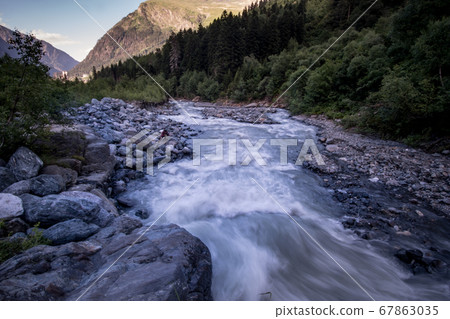 rushing blue river in a mountain forest rushing blue river in a mountain forest 67863035