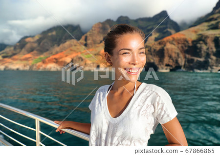 Cruise ship boat tourist on Na Pali Coast of Kauai, Hawaii. Sunset cruise ride leisure activity happy Asian tourist in NaPali. Smiling Asian woman on deck having summer holiday Cruise ship boat tourist on Na Pali Coast of Kauai, Hawaii. Sunset cruise ride leisure activity happy Asian tourist in NaPali. Smiling Asian woman on deck having summer holiday 67866865