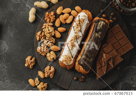 Eclair cake on dark wooden board on black table 67867015