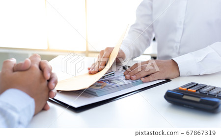 Businessmen make dollar payments while signing an investment agreement to be a partner in an illegal and successful manner, Bribery and corruption concept. Businessmen make dollar payments while signing an investment agreement to be a partner in an illegal and successful manner, Bribery and corruption concept. 67867319