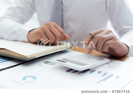 Businessmen use calculators to calculate the cost of real estate investments to prepare for offering to customers who want to share shares with the company, Business Financing Accounting Banking Conce 67867416