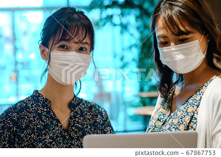 Two businesswomen with masks meeting in the office 67867753