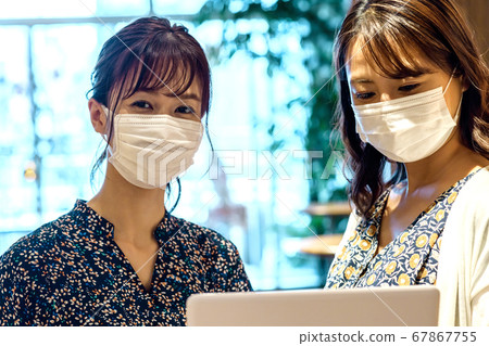 Two businesswomen with masks meeting in the office Two businesswomen with masks meeting in the office 67867755
