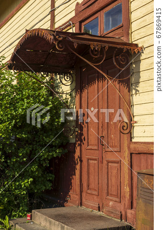 Old shabby door on a modest porch of an old house Old shabby door on a modest porch of an old house 67869415