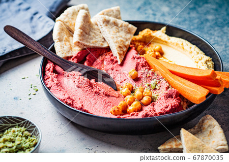 Beetroot hummus and classic hummus in black dish Beetroot hummus and classic hummus in black dish 67870035