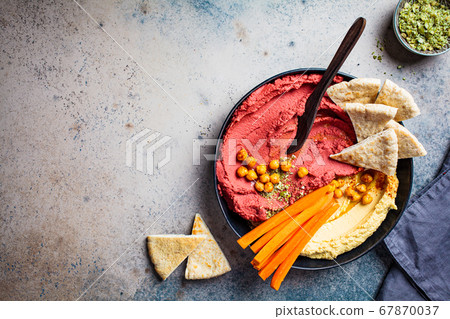 Beetroot hummus and classic hummus in black dish Beetroot hummus and classic hummus in black dish 67870037