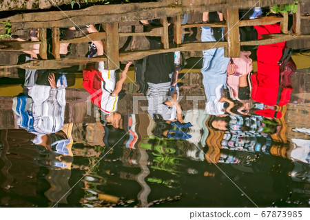 Abstract reflection of people in water 67873985