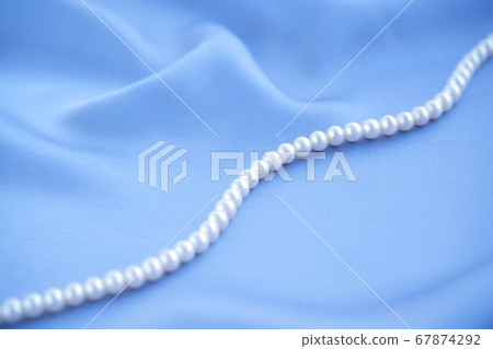 Elegant black silk background with white pearls necklace. 67874292