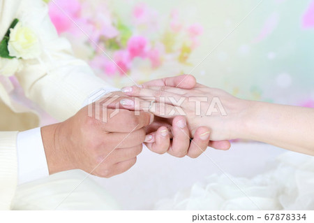 婚紗禮服與燕尾服新娘新郎結婚照片交換戒指 婚紗禮服與燕尾服新娘新郎結婚照片交換戒指 67878334