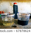 Two measuring glasses with clean and used engine 67878624