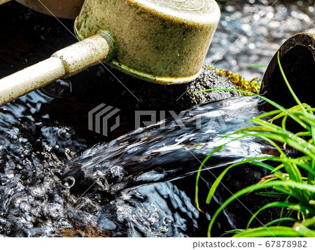 Spring water flowing out of the mountain 67878982