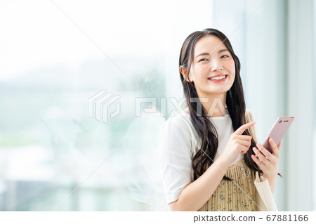 一名在校園裡操作智能手機的大學生 67881166